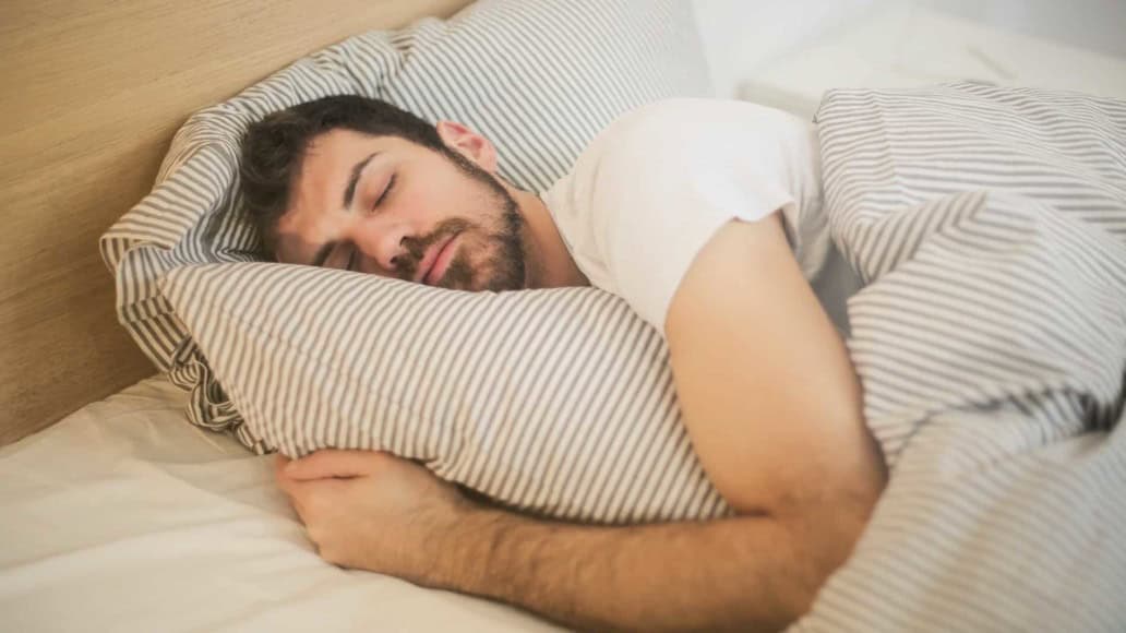 man asleep in bed