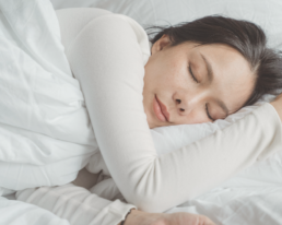 woman asleep in bed with white bedding