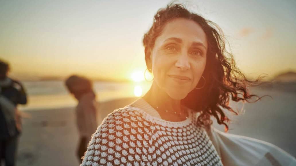 Middle aged woman at sunset on a beach