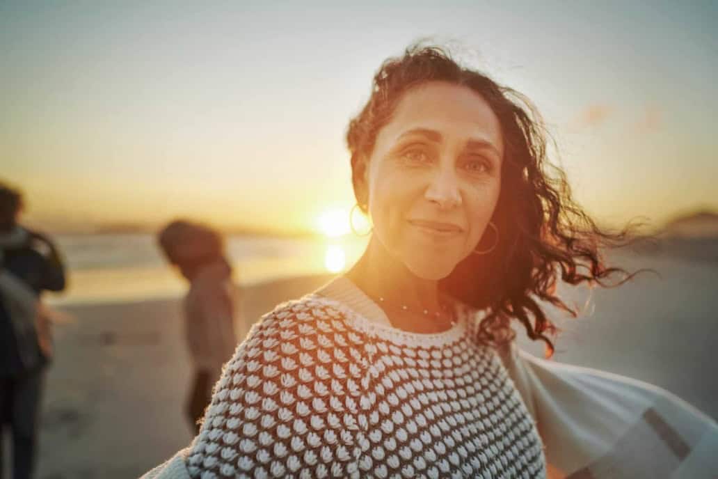 Middle aged woman at sunset on a beach