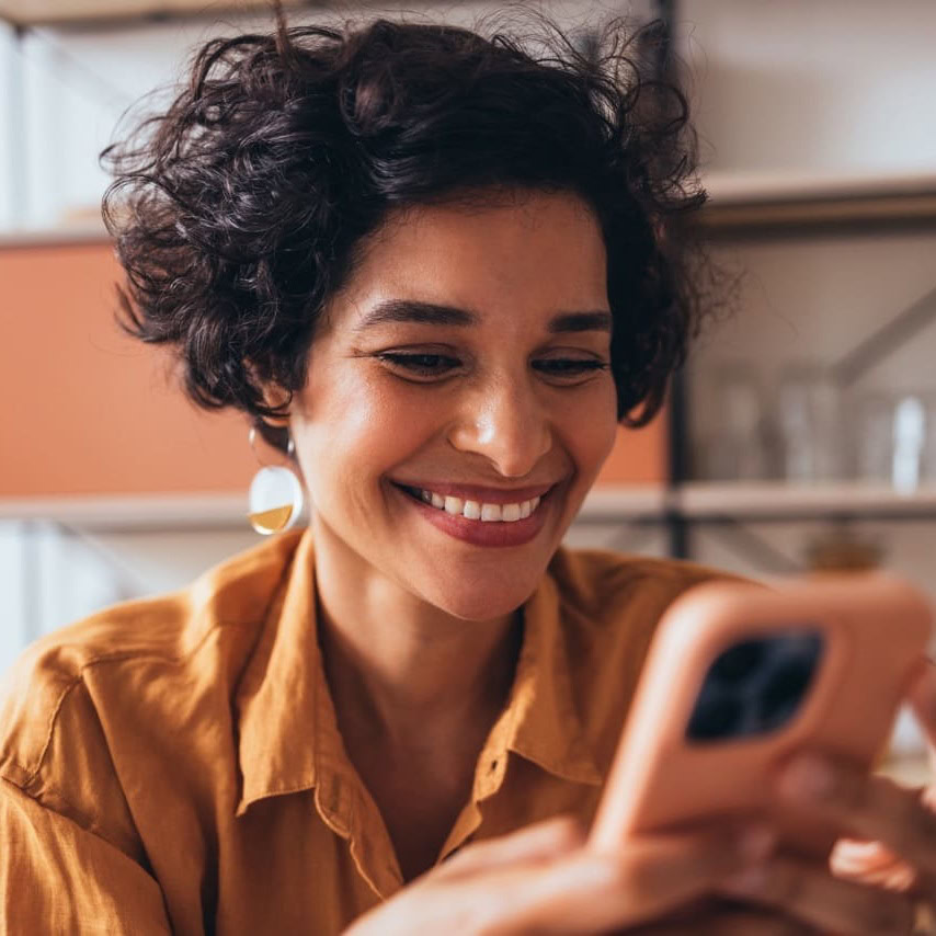 A woman in orange looking at the besophro app on phone